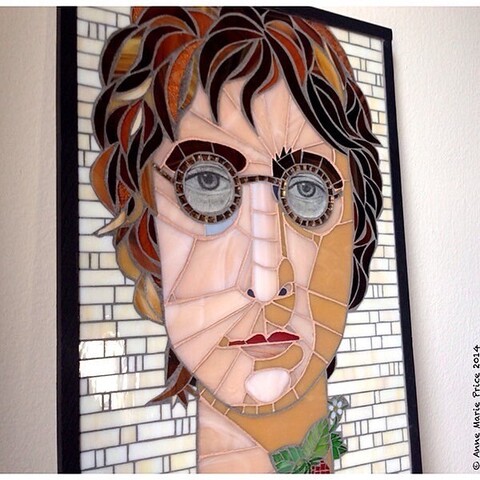 Side view of stained glass mosaic of John Lennon with an exaggerated long neck and strawberries on a strawberry vine wrapped around neck. 