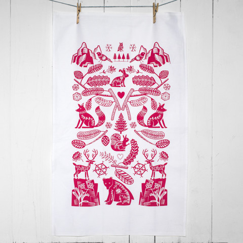 A hand printed Scandi Forest tea towel in raspberry featuring seven animals including owl, bird, hare, fox, squirrel, stag and bear.